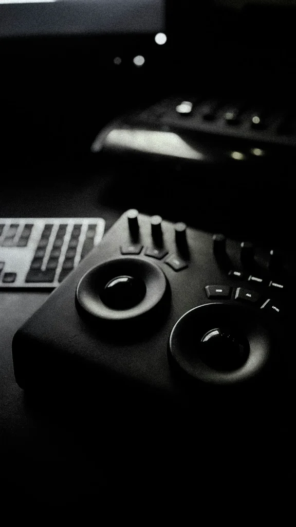 Console de montage vidéo professionnelle sur un bureau sombre, utilisée pour l’étalonnage et le post-traitement.