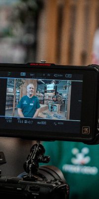 Écran de contrôle d’une caméra cadrant un employé en t-shirt vert en interview dans un magasin Maxi Zoo.